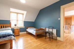 sypialnia z 2 łóżkami i niebieską ścianą w obiekcie Ballinasloe in the Heart of the Country w Galway