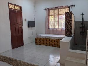 Habitación con ventana y banco junto a una puerta en Cocobongo Beach Lodge, en Dar es Salaam