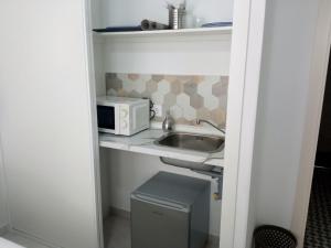 una pequeña cocina con fregadero y microondas en Los encantos de Almavir, en Córdoba