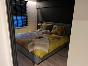 a bedroom with a bed with a yellow blanket at Luxueus nieuw zonnig hoekappartement SEAVIEW Heldenplein - 2x ruime garagebox in Knokke-Heist