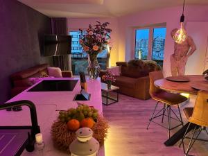 uma sala de estar com um sofá e uma mesa com frutas em Luxueus nieuw zonnig hoekappartement SEAVIEW Heldenplein - 2x ruime garagebox em Knokke-Heist