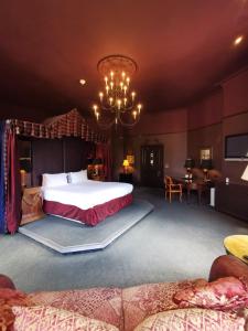 a bedroom with a large bed and a chandelier at Ruthin Castle Hotel and Spa in Ruthin