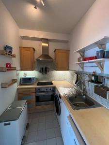 a kitchen with a sink and a stove top oven at Stylish Flat With River View in Dublin