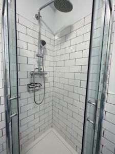 y baño con ducha y puerta de cristal. en Stylish Flat With River View en Dublín