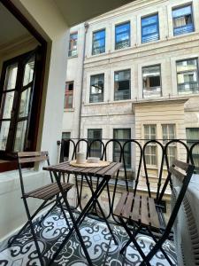 einen Tisch und Stühle auf einem Balkon mit einem Gebäude in der Unterkunft K&Y Apartments in Taksim İstiklal Street in Istanbul