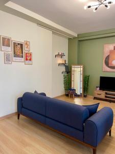 ein blaues Sofa im Wohnzimmer mit einem TV in der Unterkunft K&Y Apartments in Taksim İstiklal Street in Istanbul