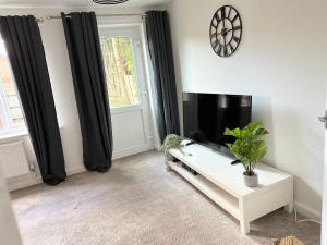 uma sala de estar com uma televisão e uma mesa branca em Fabulous 2 bed Town house free parking WiFI em Derby