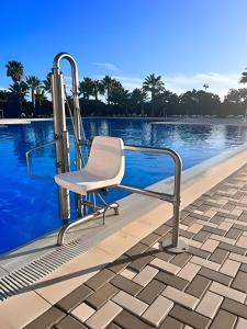 una silla sentada junto a una piscina en ISLA CANELA PLAYA Y GOLF, 1ª Línea de playa en Isla Canela