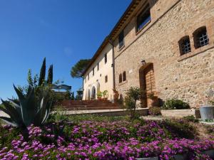 um edifício com flores roxas em frente em SCAPPO IN UMBRIA, Casale em Castello delle Forme