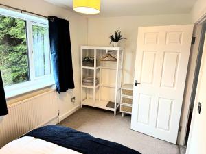 a bedroom with a white door and a window at Fabulous 2 bed Town house free parking WiFI in Derby