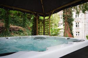 uma banheira de hidromassagem num jardim com uma árvore em Ruthin Castle Hotel and Spa em Ruthin