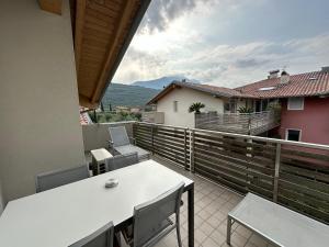 a balcony with a white table and chairs on it at 4 Limoni Apartment Resort in Riva del Garda