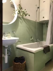 a green bathroom with a sink and a mirror at Historical, Bright & Beautiful in Old City - 3rd floor in Bern