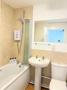 a bathroom with a sink and a toilet and a mirror at Fabulous 2 bed Town house free parking WiFI in Derby