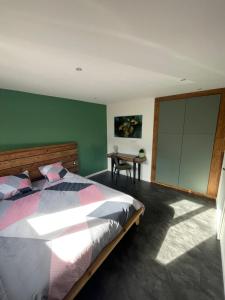 um quarto com uma cama com uma parede verde em Le Cristal Montvernier em Montvernier