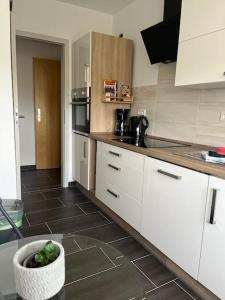 a kitchen with white cabinets and a bowl of vegetables at Gästewohnung KL. WZL 38_7 in Klein Wanzleben