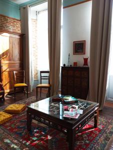 a living room with a coffee table and a window at Chambre d'hôtes PMR Hildegarde in Moissac