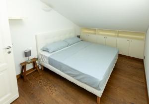 1 dormitorio con 1 cama blanca grande y suelo de madera en Maison One nel centro di Milano, en Milán