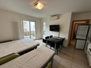 a hotel room with two beds and a table and chairs at 4 Limoni Apartment Resort in Riva del Garda +202 photos