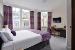 a hotel room with a bed and a desk at The Bocardo Hotel in Oxford