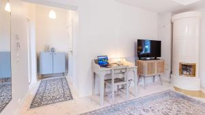 Jest to biały pokój z biurkiem, telewizorem i komputerem stacjonarnym. w obiekcie Villa Maija 3 Westside w mieście Hanko