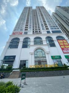 a tall white building with a sign on it at Housinco Premium - Serviced Apartments Nguyễn Xiển Street near Tops Market in Hanoi
