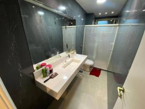 een badkamer met een wastafel, een douche en een toilet bij Apt. Luxo Cond.Mar de Conchas in Rio de Janeiro