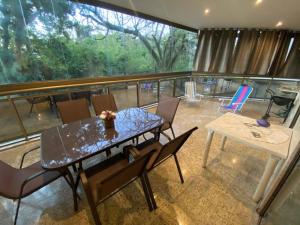 een eetkamer met een tafel en stoelen op een balkon bij Apt. Luxo Cond.Mar de Conchas in Rio de Janeiro