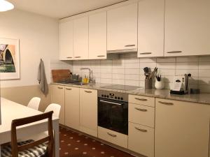 a kitchen with white cabinets and a stove at Historical Flat, by Zytglogge - 1st Floor in Bern