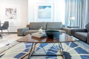 S Plaza Suites Hotel في Seef: غرفة معيشة مع أريكة وطاولة قهوة