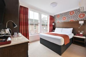 a hotel room with a bed and a large window at The Bocardo Hotel in Oxford