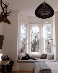 a woman sitting on a couch in a window at Flash Jacks of Gundagai in Gundagai