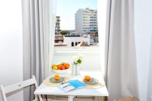 a white table with a bowl of fruit and a window at Xtraordinary Moments Apartment in Faro