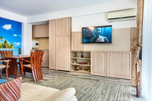 a kitchen and dining room with a tv on the wall at Apartament Madagascar Boutik Cytadell in Eforie Nord