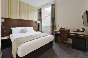 a hotel room with a bed and a desk with a computer at The Bocardo Hotel in Oxford