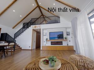 een woonkamer met een trap en een tafel bij Mya Lakeview Villa Biệt Thự in Bao Loc