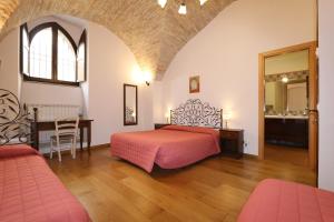 a bedroom with a bed and a table and chairs at La Casina Colorata in Assisi