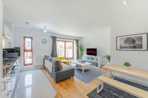 a living room with a couch and a table at The Waterloo Apartment - Large Private Patio & Air Conditioning in London