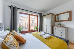 una camera da letto con un grande letto con una coperta gialla di The Waterloo Apartment - Large Private Patio & Air Conditioning a Londra
