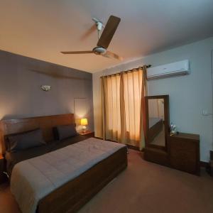 a bedroom with a bed and a ceiling fan at Private Suite F-10 Islamabad in Islamabad