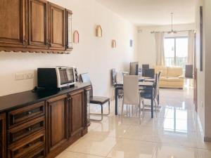 a kitchen and dining room with a table with a microwave at XL Central Home - Sleeps 10 people in Pieta