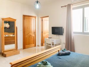 1 dormitorio con 1 cama y TV en XL Central Home - Sleeps 10 people, en Pieta