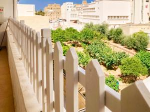 a white fence on a building with trees and buildings at XL Central Home - Sleeps 10 people in Pieta