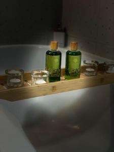 two bottles of soap and bowls on a wooden shelf in a bath tub at The Dachshund's Chateau in Budíkov