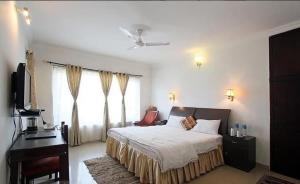 Dormitorio con cama, escritorio y TV en Van Durga Villas & Suites, en Padmi