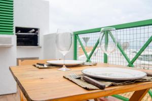 uma mesa de madeira com um prato e um copo de vinho em Duplex Vista Mar na Praia Brava YF7387 em Florianópolis
