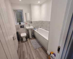 a bathroom with a tub and a toilet and a sink at Cosyhome in Wellingborough