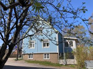 ein blaues Haus mit weißen Fenstern und einem Baum in der Unterkunft Uusi asunto, upea sijainti in Turku