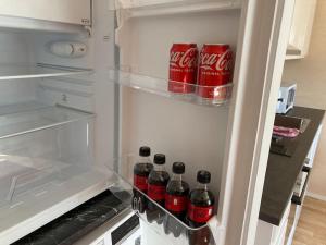an open refrigerator with coca cola bottles in it at Uusi asunto, upea sijainti in Turku