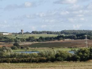 uma vista para um campo com uma torre de água à distância em Cosyhome em Wellingborough